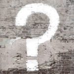 Question mark on brick wall